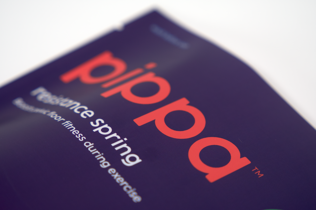 Close-up, artfully cropped image of a Pippa resistance spring branded package on a white background
